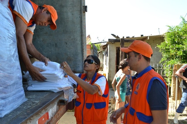 Equipe da Defesa Civil fazendo a entrega dos donativos